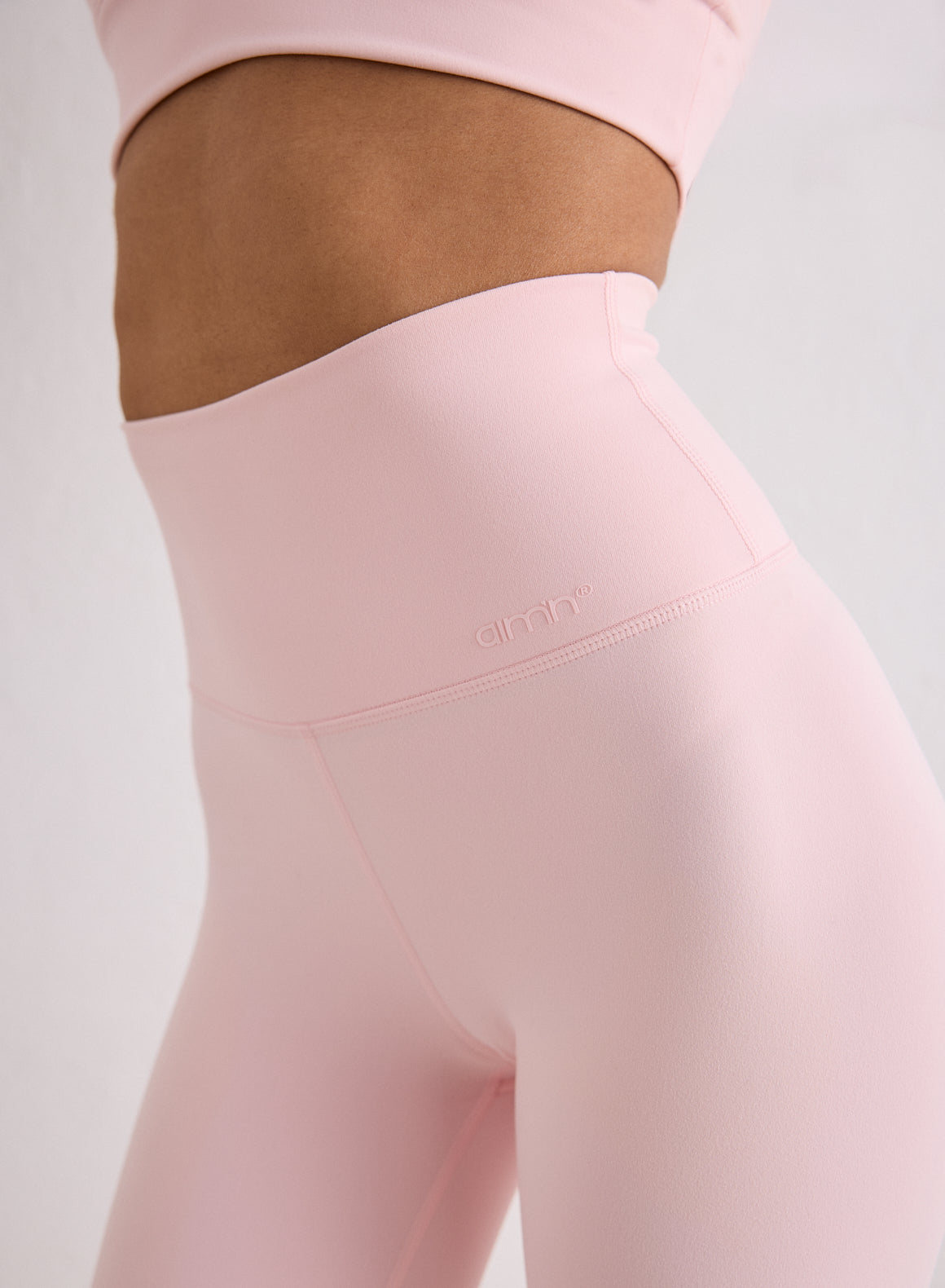 Close-up of the high waistband on the pink Ballerina Sense Tights with a tonal aim'n logo [XS-170cm]